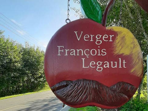 L'enseigne en forme de pomme du Verger François Legault à l'entrée